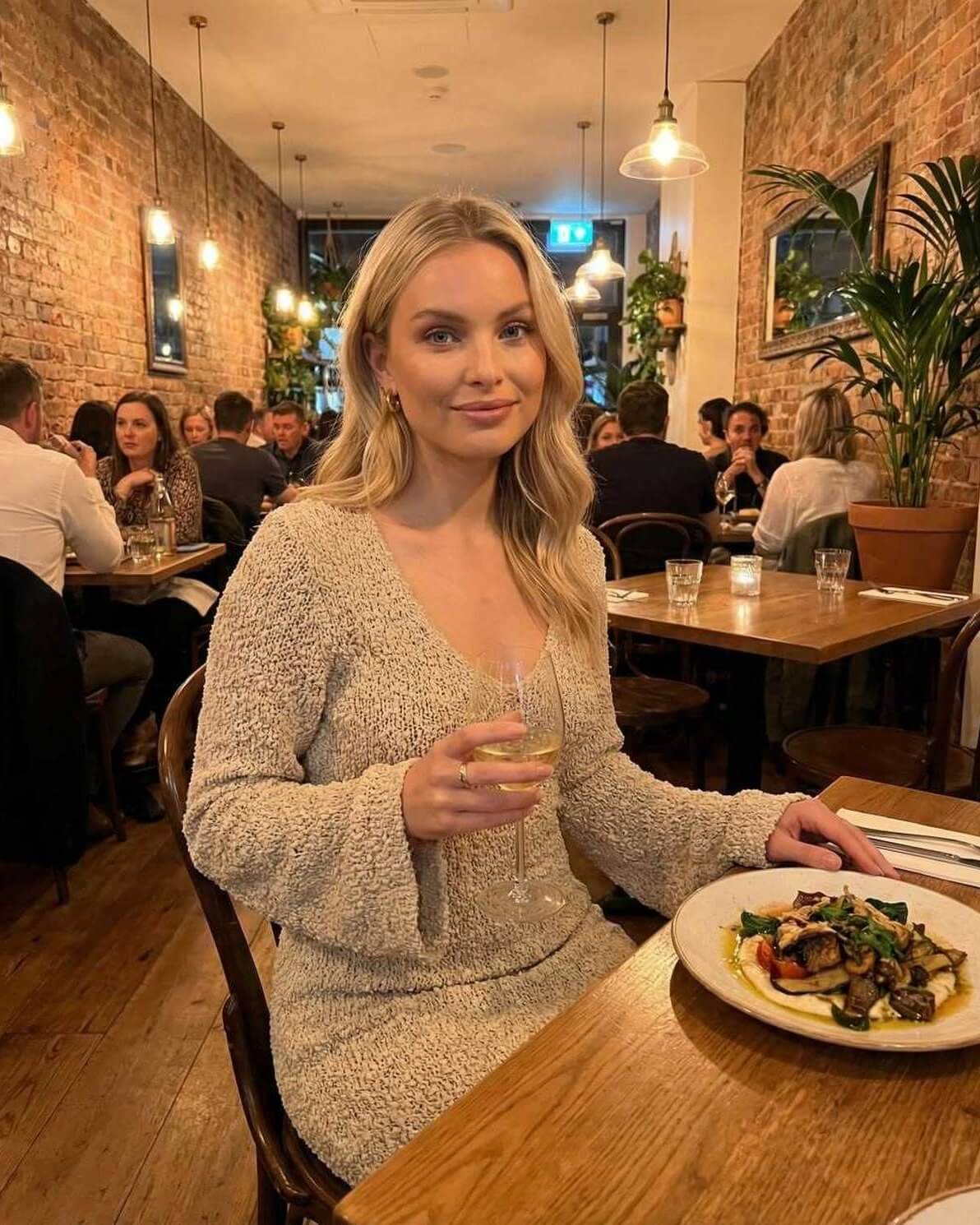 Sienna Maxi Dress by Lauven, beige sweater dress with long sleeves, elegant dining atmosphere, and delicious plate of food.