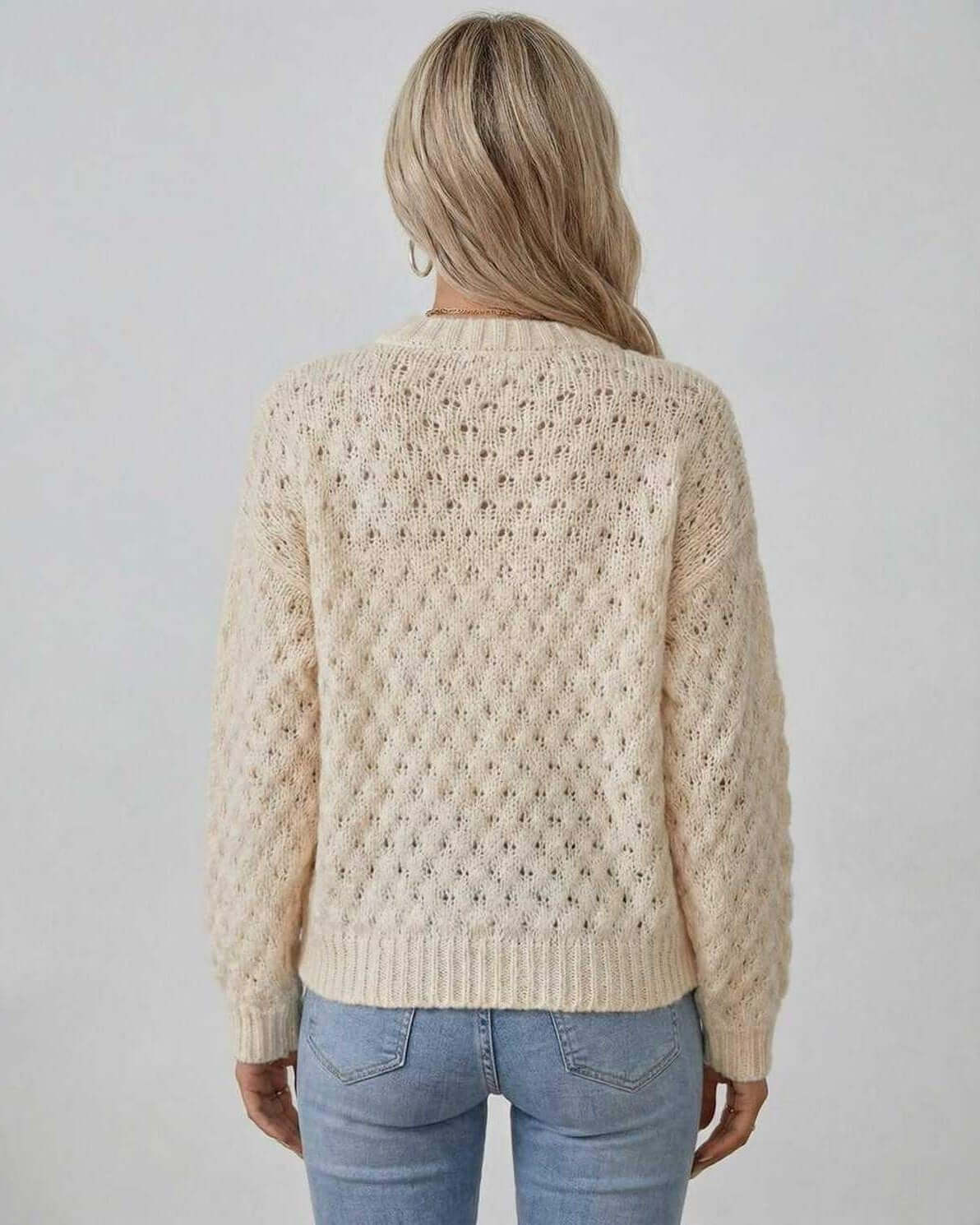 Back view of a woman wearing the Arden Sweater by Lauven, featuring a cream cable knit design.