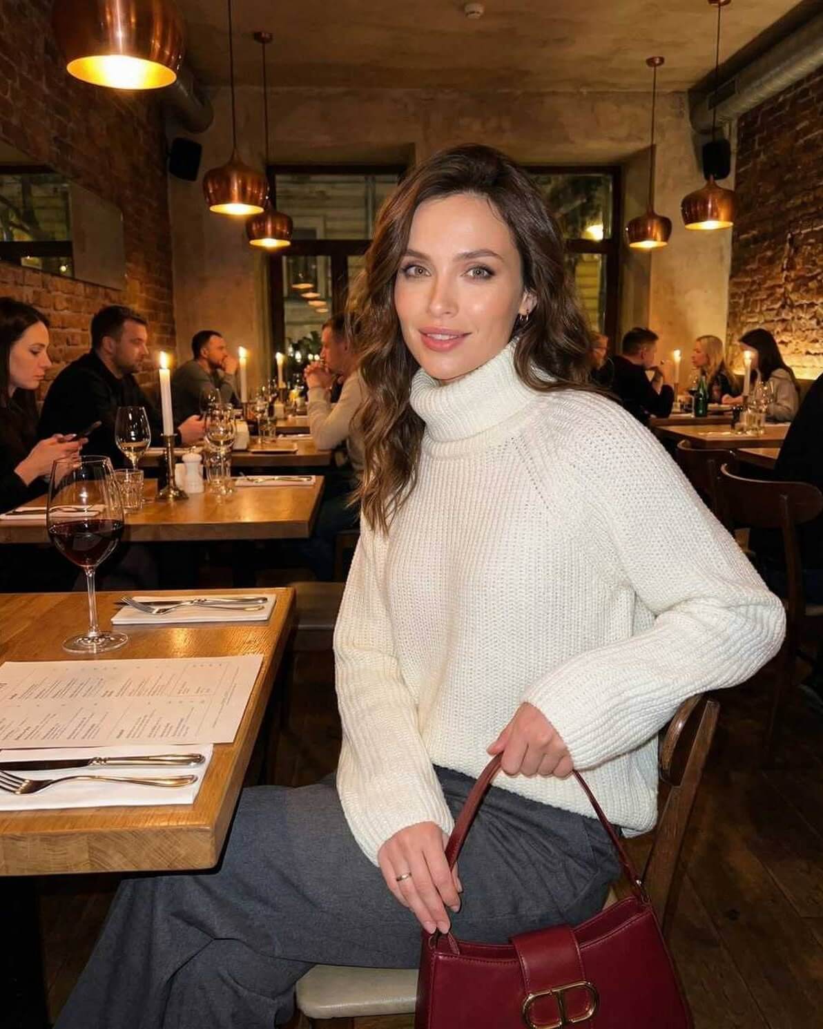 Aspen Sweater by Lauven – Women’s Cream Turtleneck Sweater in a cozy restaurant setting.