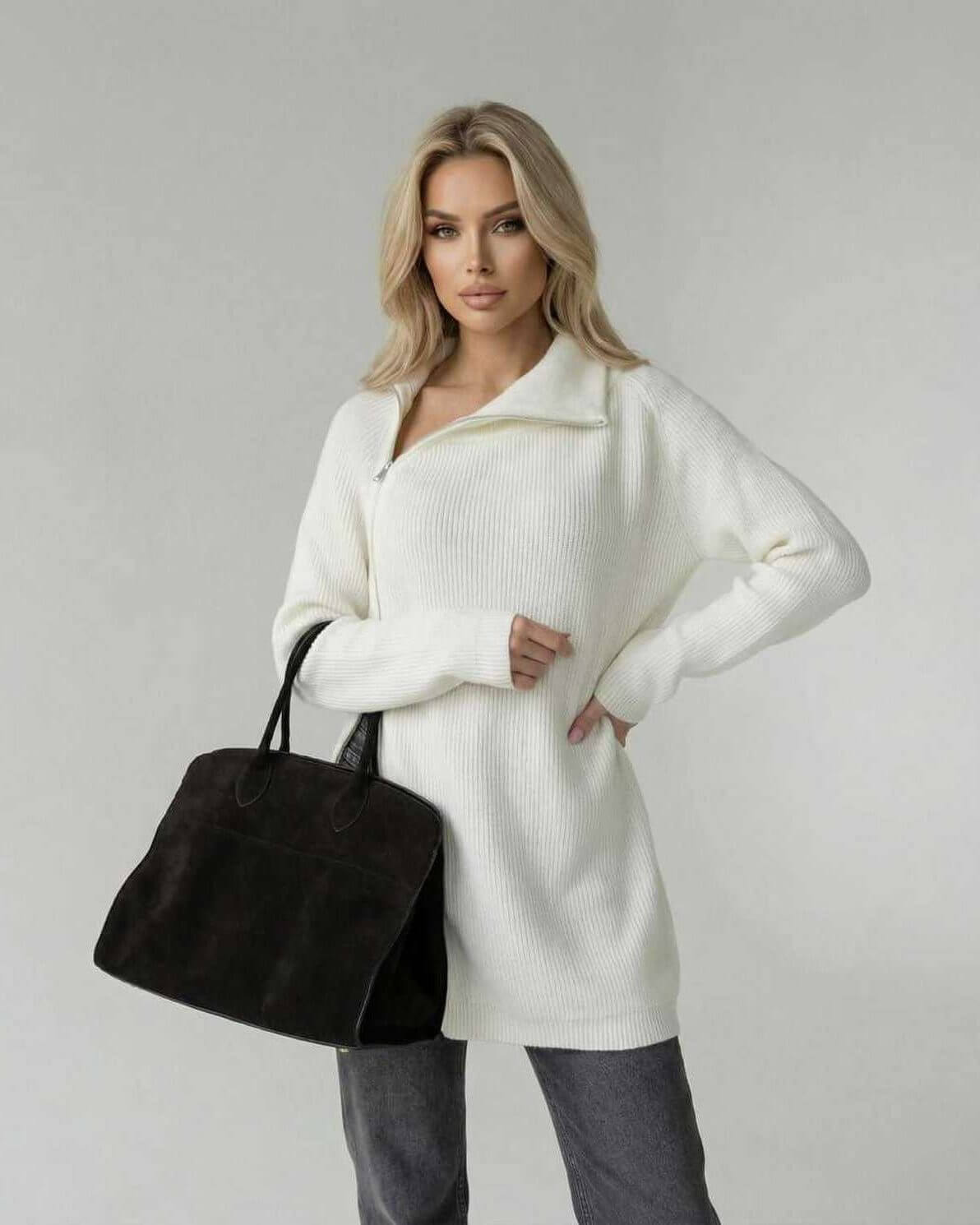 Women wearing Aspen Sweater by Lauven, a white turtleneck long sleeve sweater, stylishly holding a black bag.