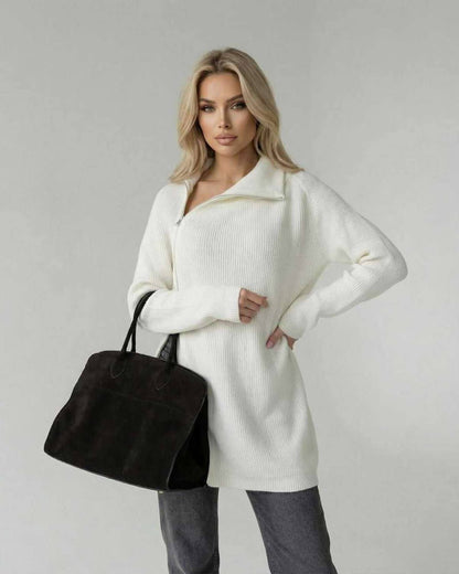 Women wearing Aspen Sweater by Lauven, a white turtleneck long sleeve sweater, stylishly holding a black bag.