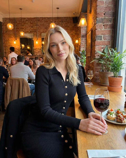 Monaco Midi Dress by Lauven worn by a smiling woman in a restaurant with wine and food, showcasing gold button details.