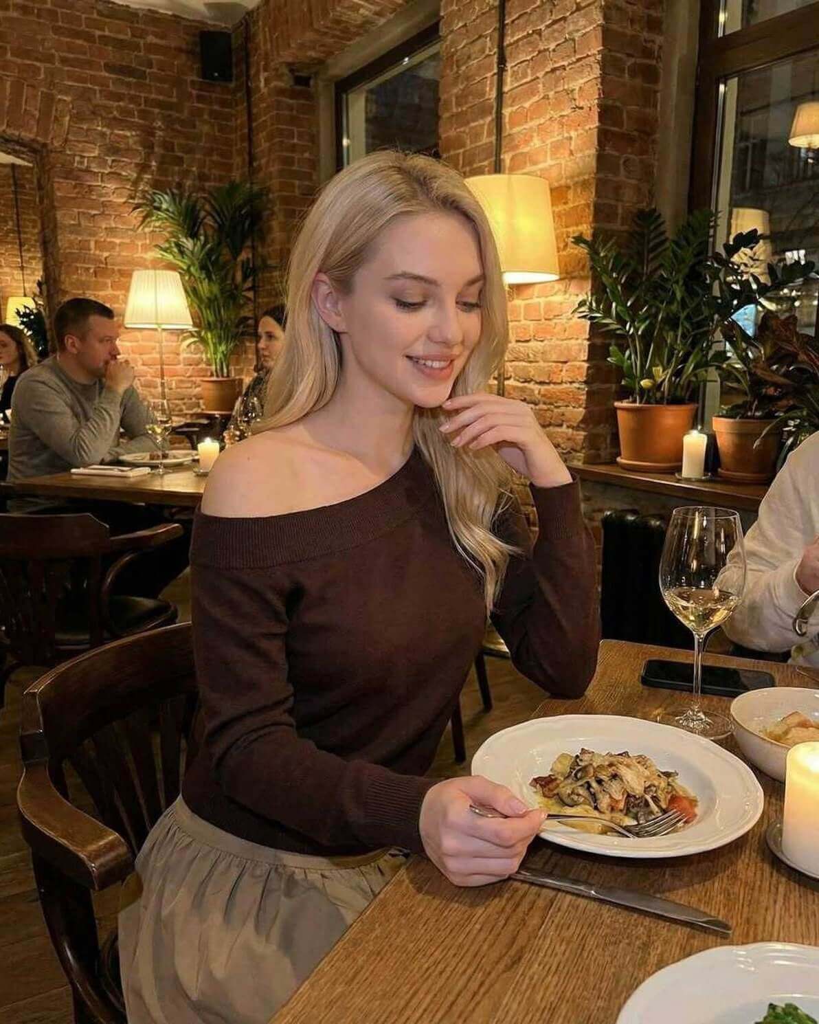 Verona Pullover by Lauven – Women’s brown off shoulder sweater styled at a cozy restaurant.