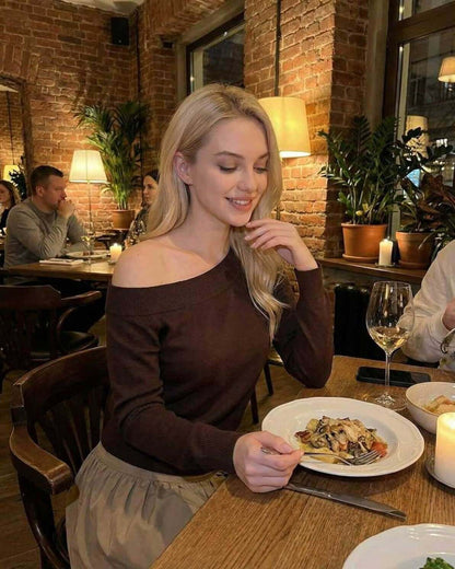 Verona Pullover by Lauven – Women’s brown off shoulder sweater styled at a cozy restaurant.