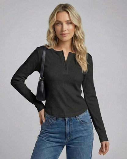 Woman wearing Vesper Long Sleeve black henley top with button placket and fitted silhouette.