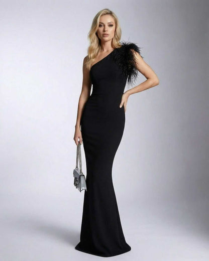 Noirelle Maxi Dress by SLIMONA - Elegant black one shoulder design with feather detail and mermaid silhouette.