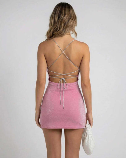 Back view of a model wearing the SLIMONA Rosé Mini Dress with crisscross straps and a soft pink shimmer.
