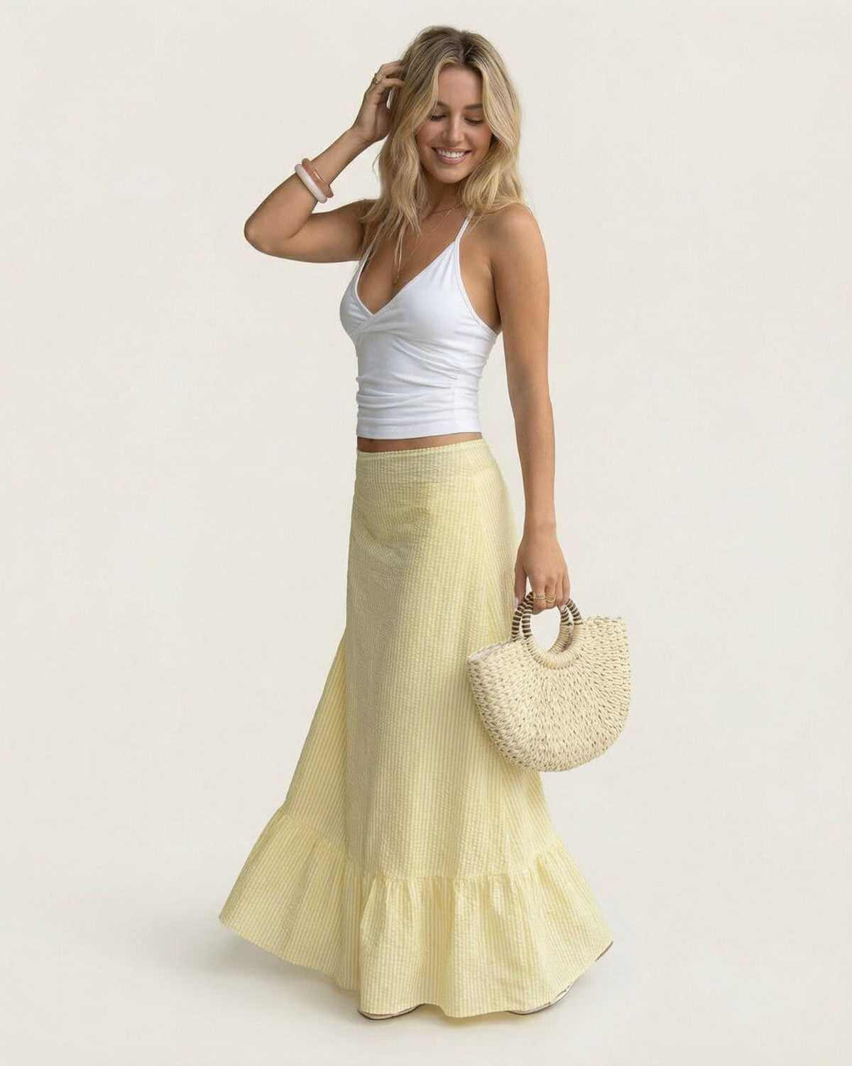 Model wearing Solara Maxi Skirt by SLIMONA, featuring a flared silhouette and soft striped texture for summer elegance.