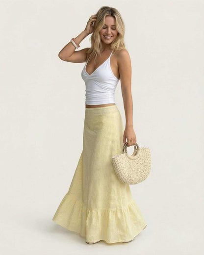 Model wearing Solara Maxi Skirt by SLIMONA, featuring a flared silhouette and soft striped texture for summer elegance.