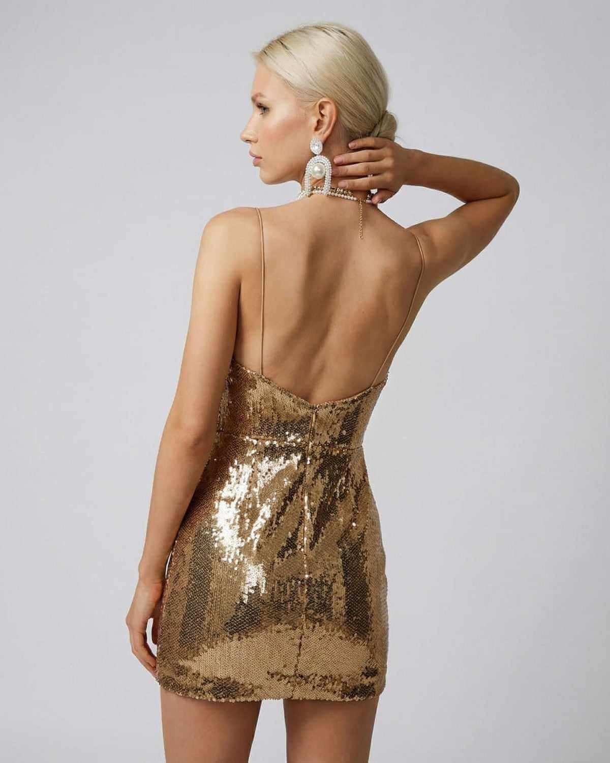 Aureon Mini Dress by SLIMONA featuring a draped V-neckline and gold sequins for a glamorous evening look.