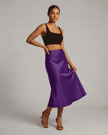 Model wearing Amethyst Midi Skirt by SLIMONA, showcasing a satin mermaid design and vibrant purple hue.