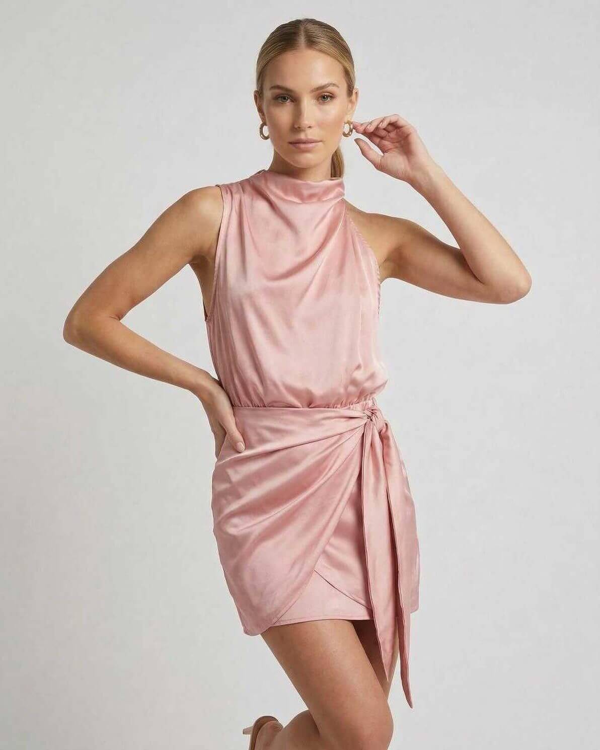 Aria Mini Dress by Lauven in pink satin with draped high neck and wrap tie detail, showcasing a stylish sleeveless silhouette.