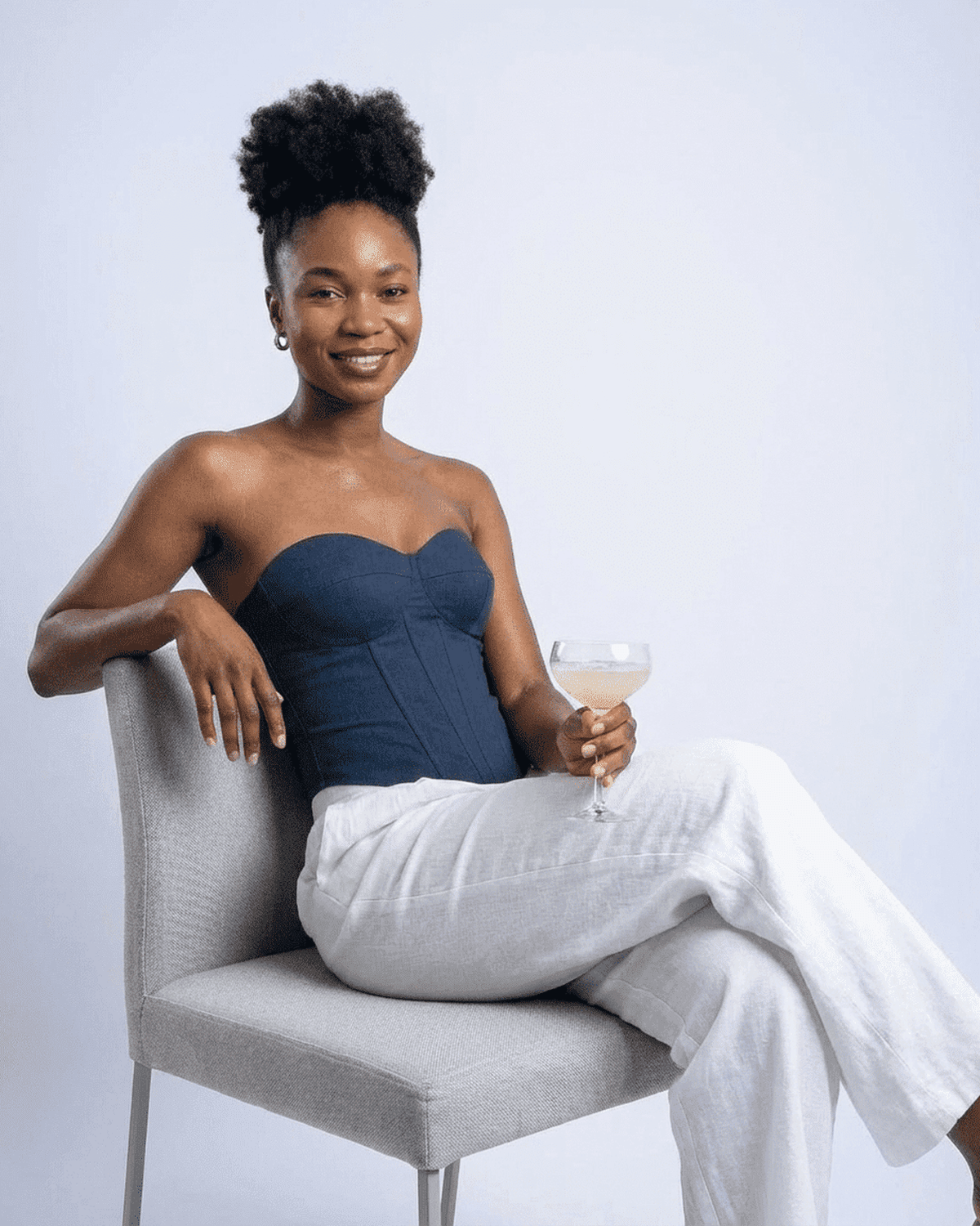 Model wearing Atlas Corset Top by SLIMONA, showcasing a faux denim cup bustier look with a cocktail.