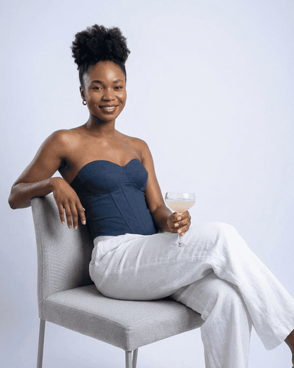Model wearing Atlas Corset Top by SLIMONA, showcasing a faux denim cup bustier look with a cocktail.