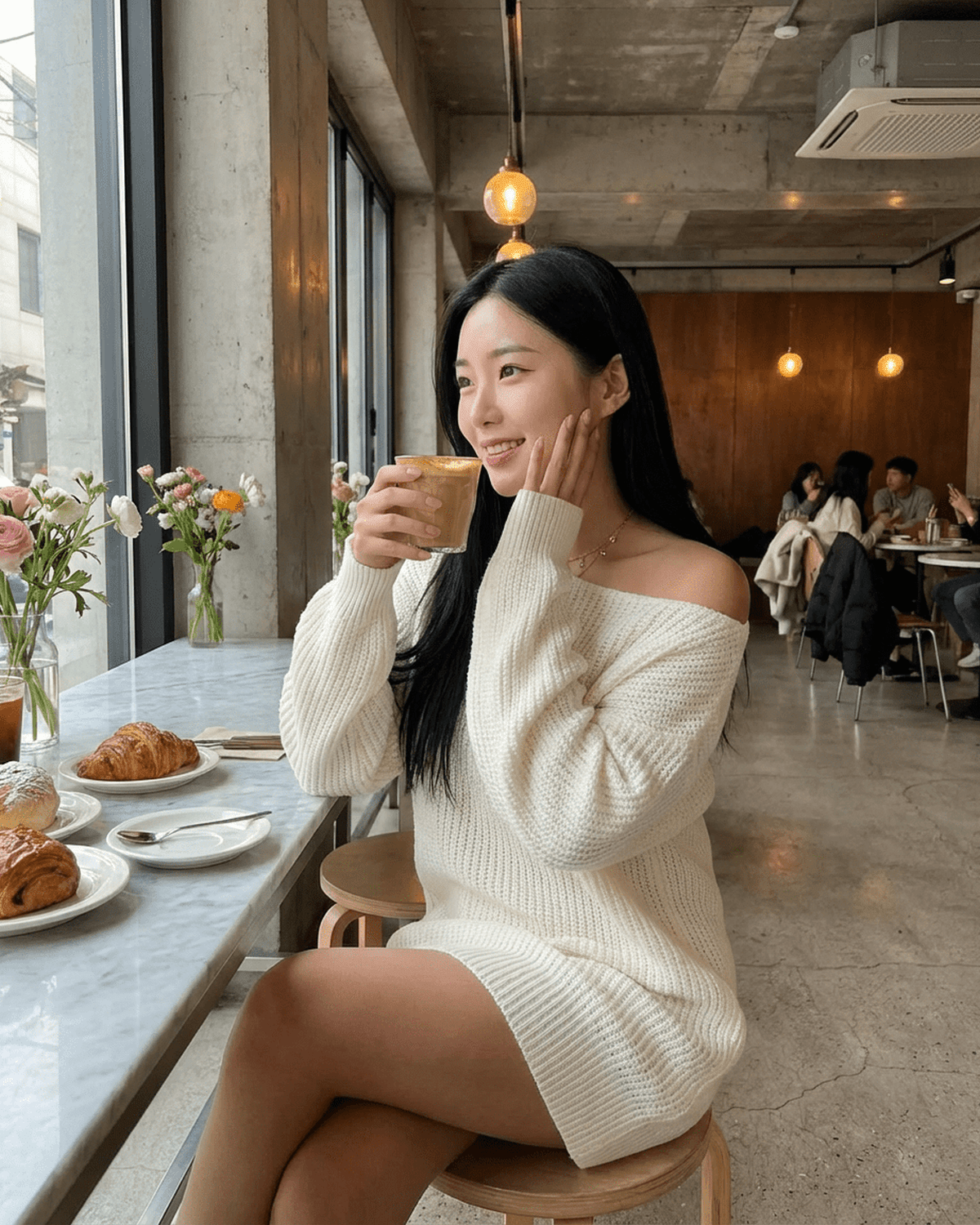 Model wearing the Aurora Mini Dress with off-the-shoulder sleeves, enjoying coffee in a cozy cafe.