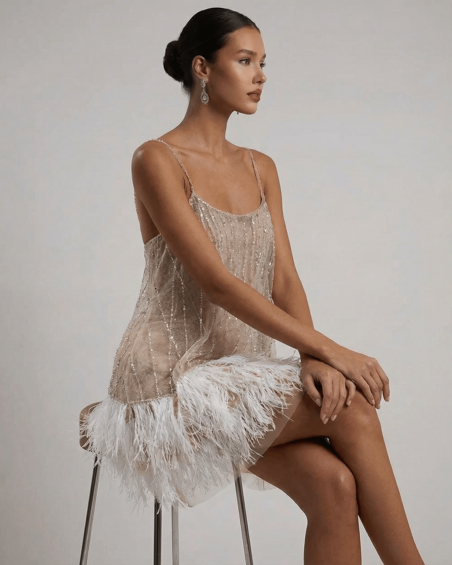 Celeste Mini Dress by SLIMONA featuring a sequin tulle design and feather tassel hem, showcasing modern glamour.