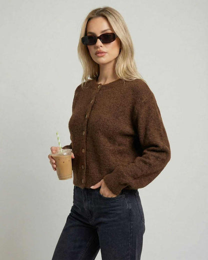 Cocoa Cardigan by Lauven modeled by a woman holding a drink, showcasing its button-front design and relaxed fit.