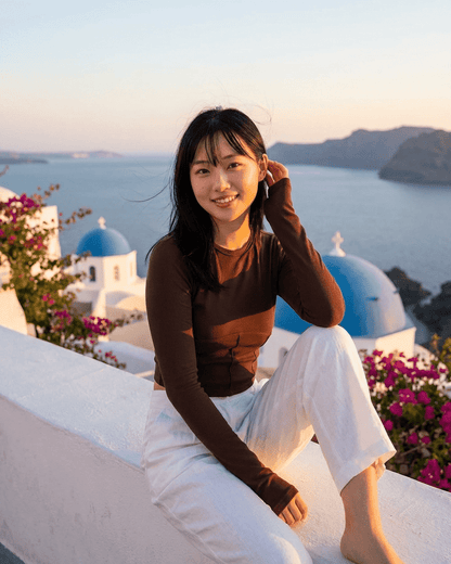 A woman wearing a Cocoa Corset Top against a scenic backdrop, showcasing the stylish design of the SLIMONA brand.