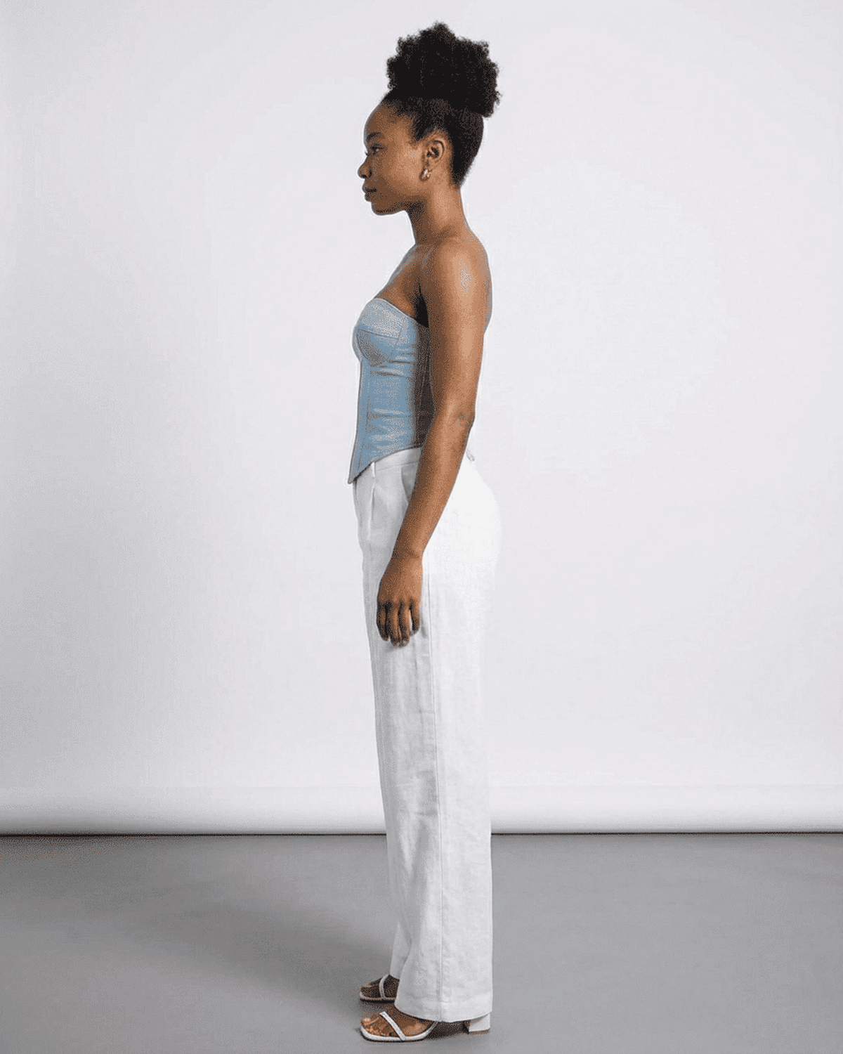 Model wearing Denali Corset Top by SLIMONA, showcasing faux denim fabric in a sleek, structured design.