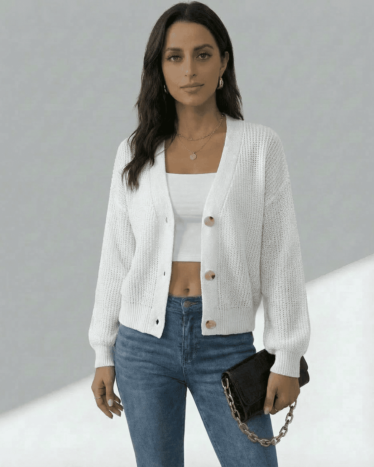 Model wearing the Elara Cardigan by SLIMONA, a lightweight button-front knitwear in white, styled with jeans.