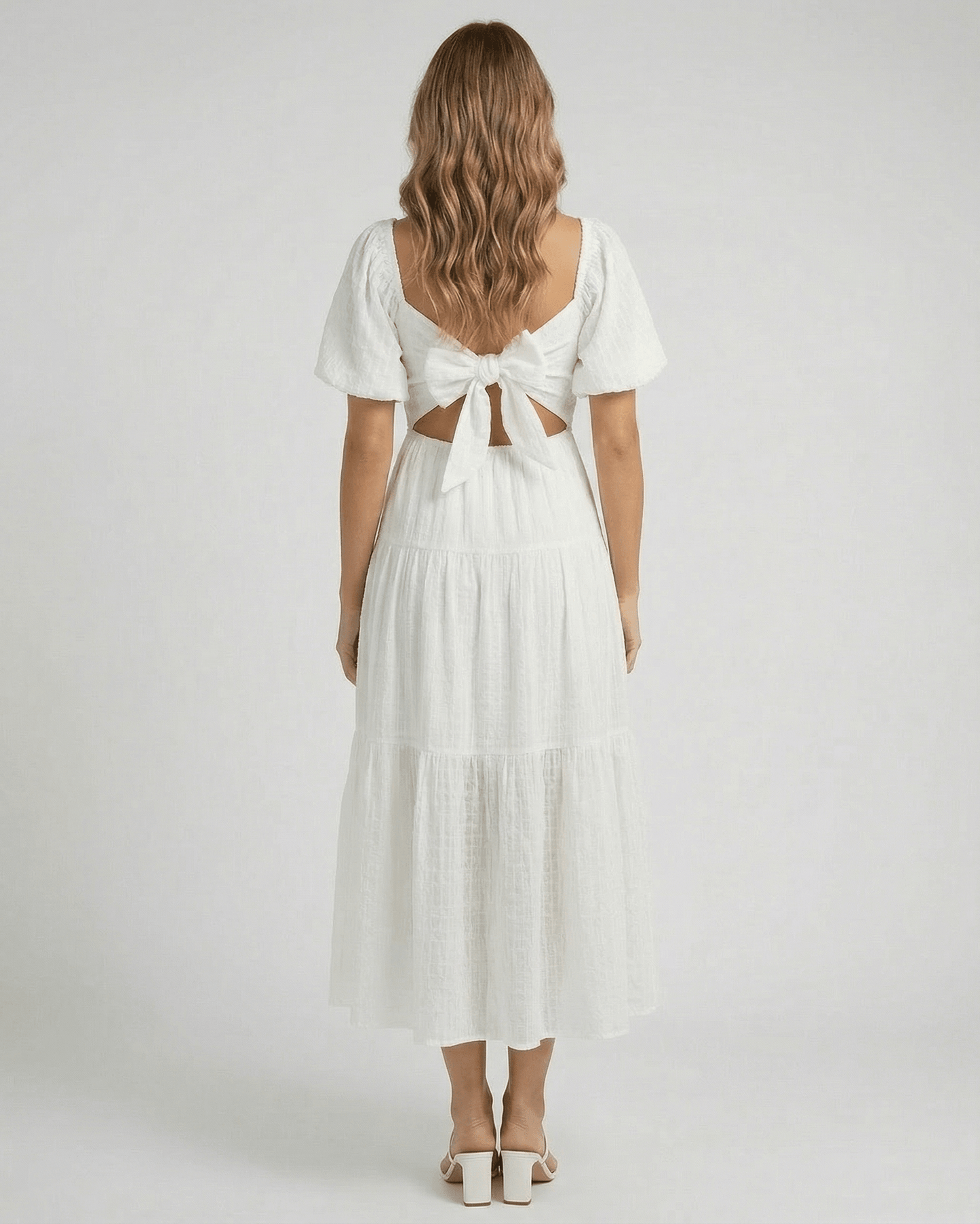 Back view of the Elara Midi Dress by Lauven with puff sleeves and a bow detail in elegant white.