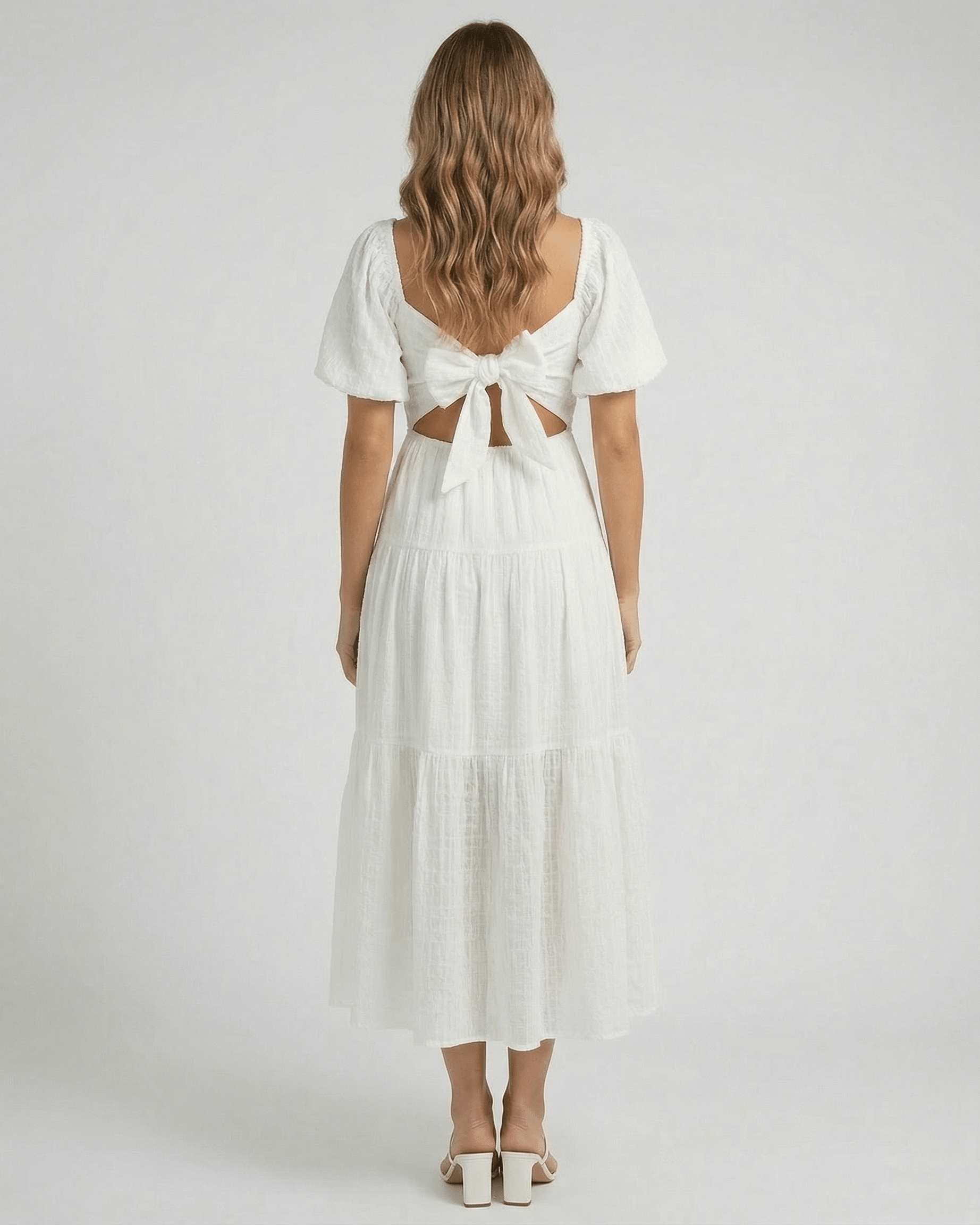 Back view of the Elara Midi Dress by Lauven with puff sleeves and a bow detail in elegant white.