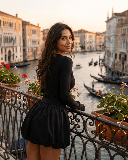 Elara Mini Dress by SLIMONA, elegant long sleeve tiered mini dress against a scenic backdrop.