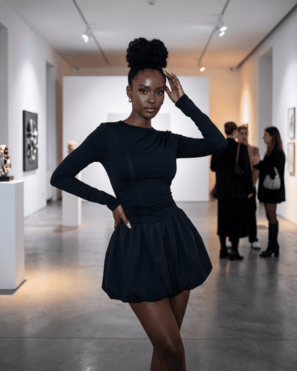 Elara Mini Dress by SLIMONA worn by model in an art gallery showcasing elegant long sleeve tiered design.