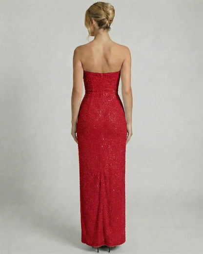 Back view of a woman wearing the SLIMONA Scarlet Maxi Dress, featuring an embellished bandeau silhouette and draped cowl detail.