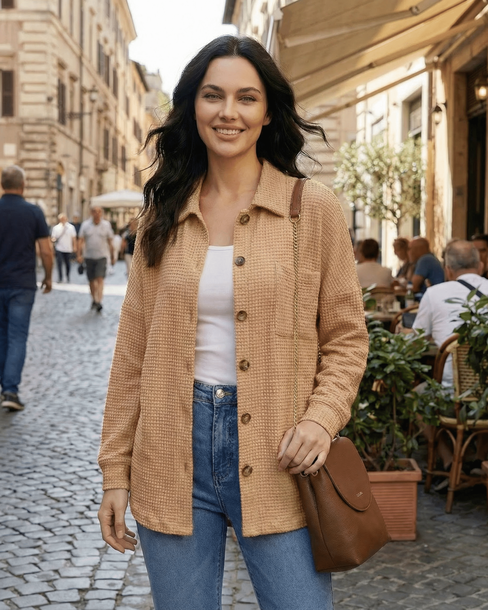 Model wearing Sienna Jacket by Lauven, a beige waffle knit longline casual fit in an outdoor cafe setting.