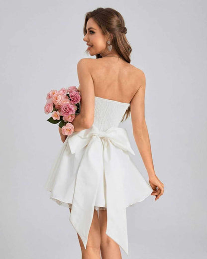 Ivoria Mini Dress by SLIMONA - Strapless high-waist mini dress with soft volume, holding pink roses.