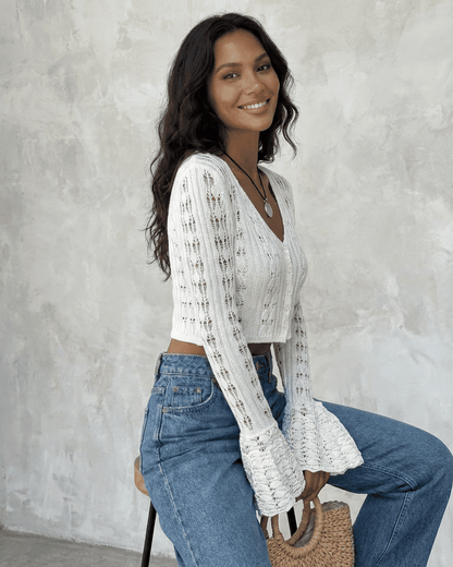 Model wearing the Laceflare Cardigan by SLIMONA, showcasing its elegant white knit and flare sleeves.