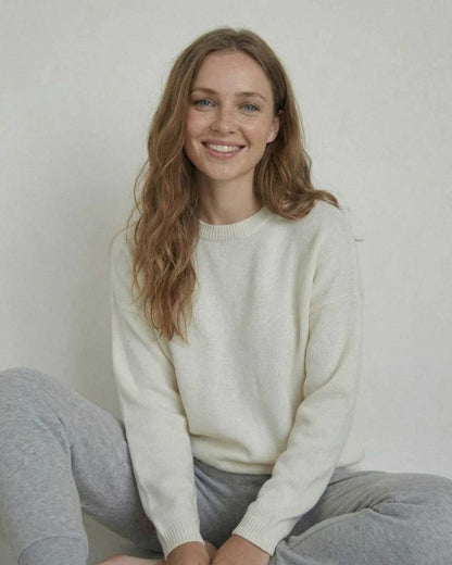 Woman smiling in the Alba Pullover by SLIMONA, a relaxed wool knit sweater for everyday style.