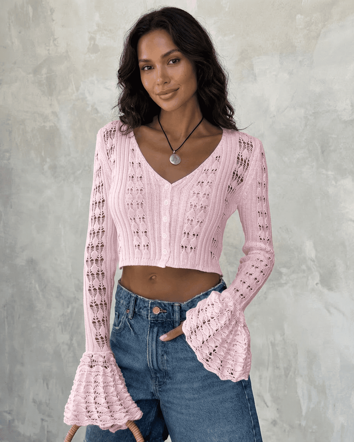 SLIMONA Blossom Cardigan in pink, cropped cotton knit with flare sleeves and V-neckline on a model.