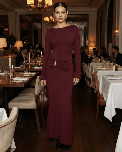 Elegant woman in Bordeaux Maxi Dress by Lauven at a candlelit restaurant table setting.