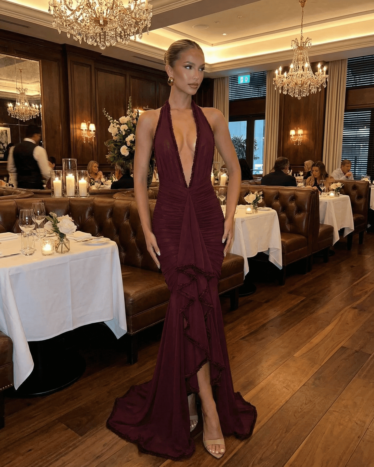 Bordeaux Maxi Dress by SLIMONA showcased in an elegant restaurant setting, featuring a plunging V-neckline and stylish lace detail.