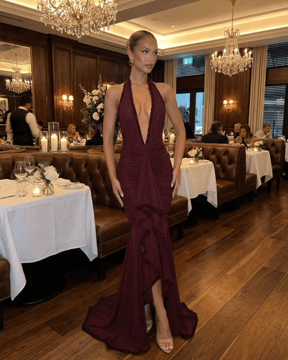 Bordeaux Maxi Dress by SLIMONA showcased in an elegant restaurant setting, featuring a plunging V-neckline and stylish lace detail.