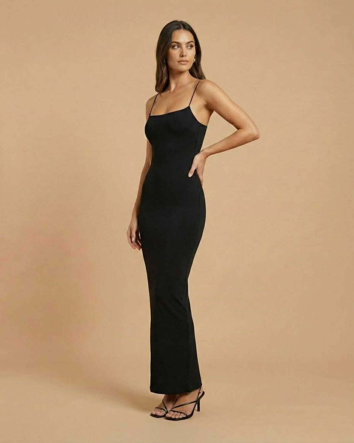 Calypso Maxi Dress by SLIMONA, showcasing a sleek black backless design with spaghetti straps and a fluid drape.
