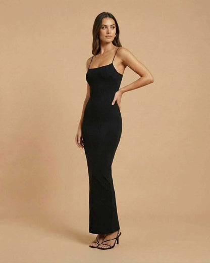 Calypso Maxi Dress by SLIMONA, showcasing a sleek black backless design with spaghetti straps and a fluid drape.