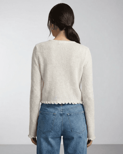 Back view of women wearing the Camellia Cardigan by SLIMONA, showcasing its floral button details and soft knit texture.