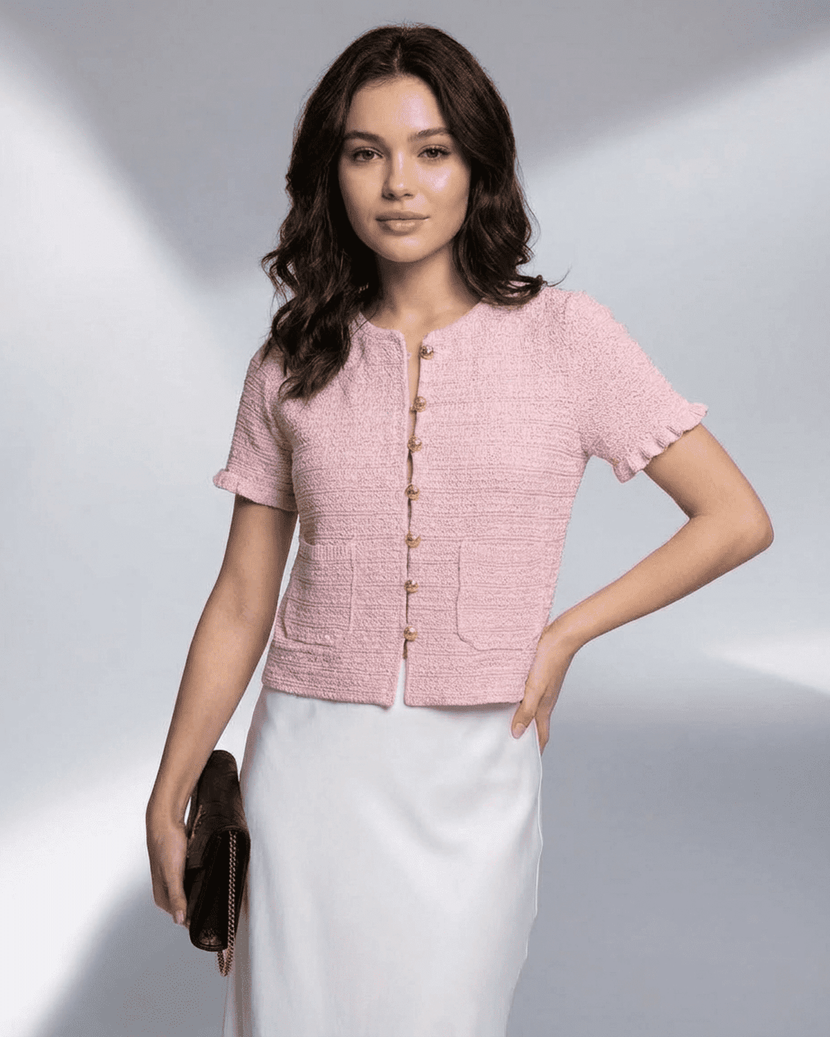 Alt Tag: Elegant woman wearing a pink Camellia Cardigan from SLIMONA, featuring short sleeves and button closure.