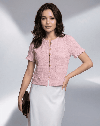 Alt Tag: Elegant woman wearing a pink Camellia Cardigan from SLIMONA, featuring short sleeves and button closure.