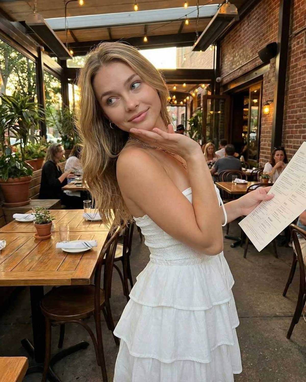 Capri Mini Dress by Lauven, off-shoulder A-line silhouette with tiered skirt, worn in a cozy restaurant setting.