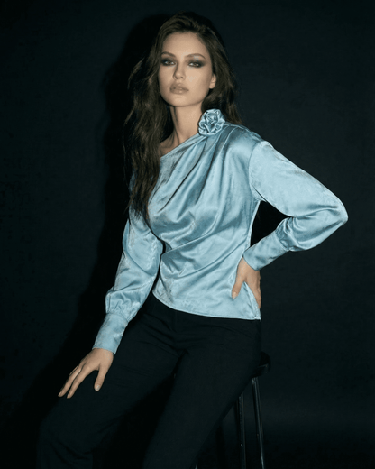 Model wearing the Celeste Blouse by SLIMONA, showcasing an asymmetrical neck and satin-style finish.