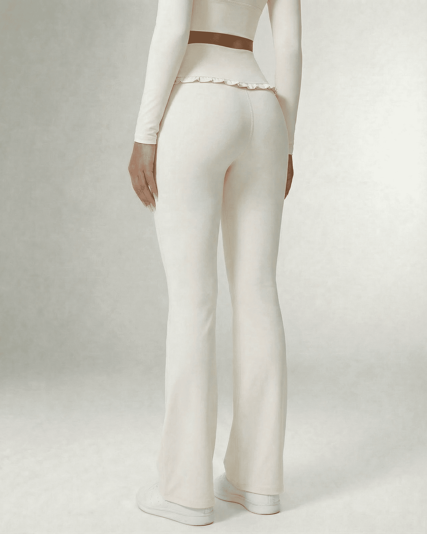 Celeste Leggings by SLIMONA featuring elegant white flare pants with pockets and ruffle detailing, showing back view.