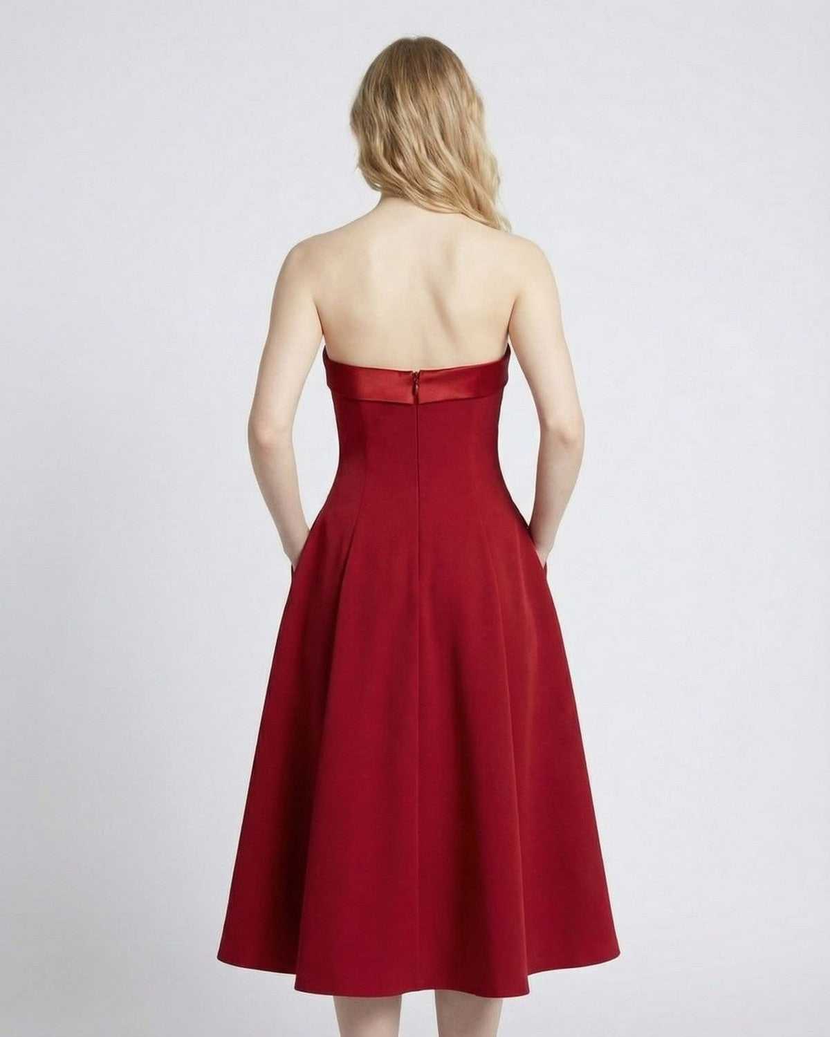 Back view of a model wearing the SLIMONA Celeste Midi Dress, showcasing its elegant strapless design and pockets.