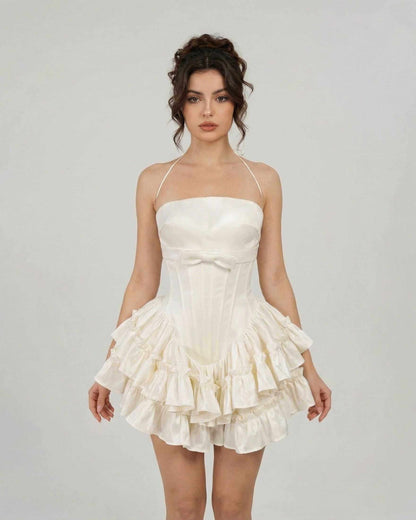 Celeste Mini Dress by SLIMONA, a soft white, corset-inspired tiered mini dress with delicate straps.
