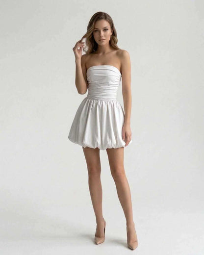 Celeste Mini Dress by Lauven, elegant strapless white satin A-line mini dress with ruched bodice and playful bubble skirt.