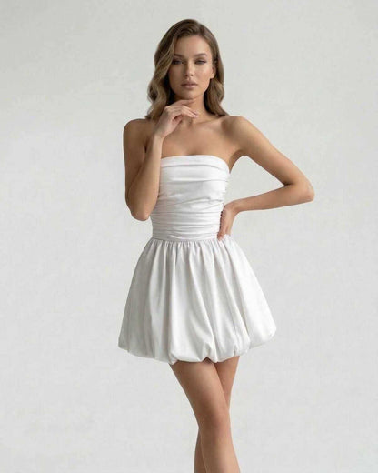Celeste Mini Dress - Elegant strapless white satin A-line mini dress by Lauven, showcasing a ruched bodice and bubble hem.