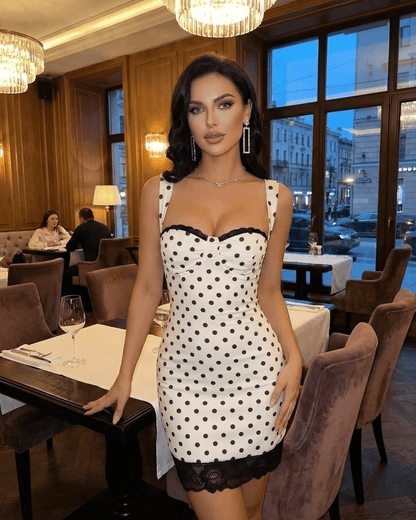 Celeste Mini Dress by SLIMONA, showcasing a polka dot design with lace trim in a stylish restaurant setting.